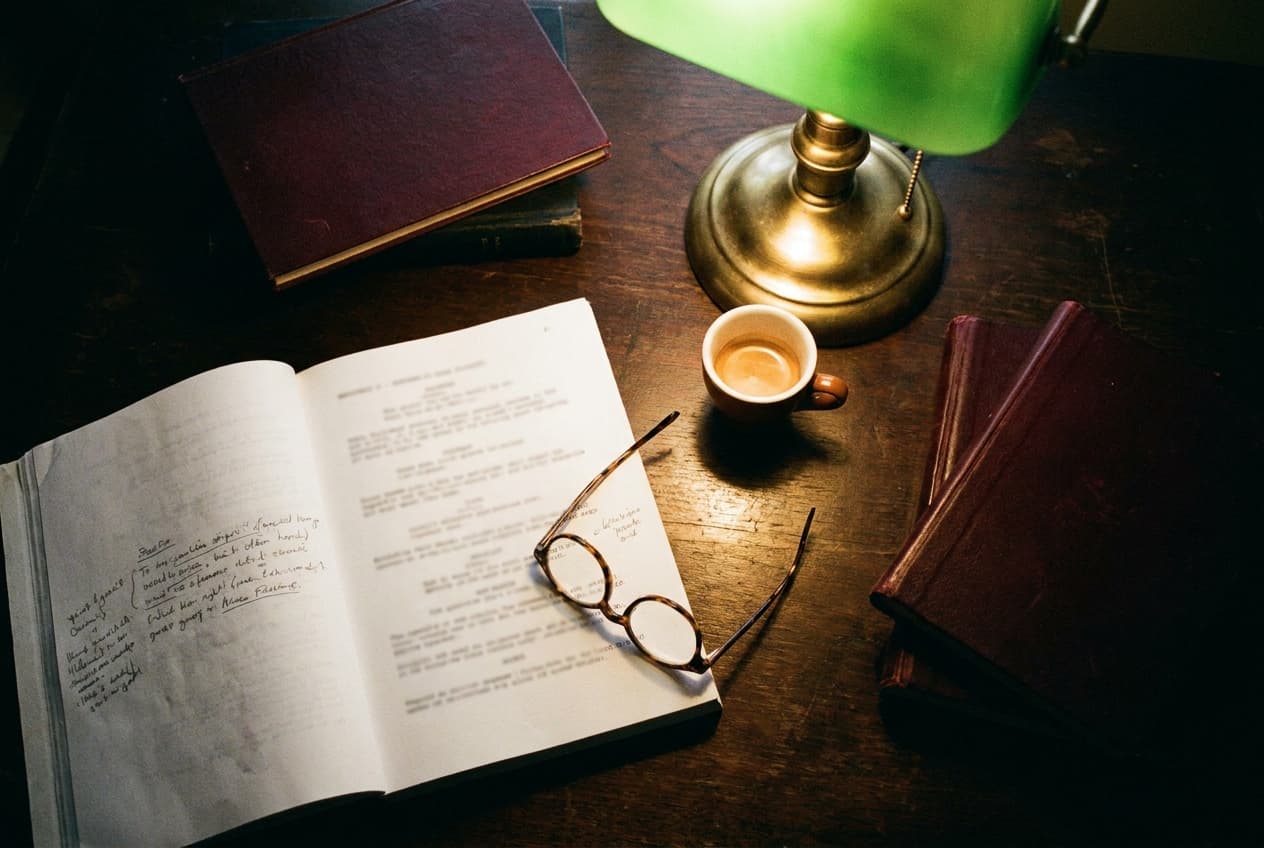 Drehbuch mit Notizen und Messinglampe